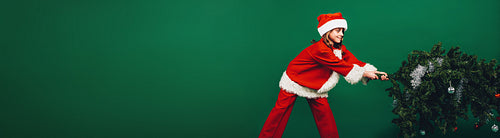 Santa girl setting up a christmas tree