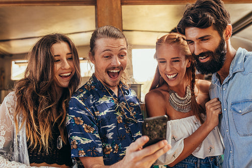 Laughing friends taking selfie with cellphone.