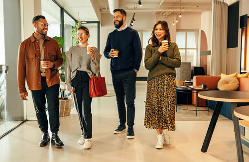 Diverse businesspeople walking through an office in the morning