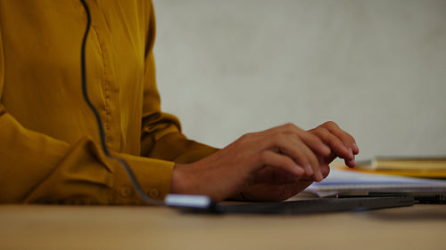 Businesswoman typing and speaking on headset in office