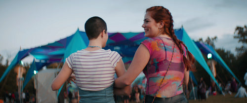 Excited female friends hugging at a festival