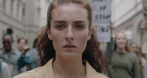 Woman in climate march with people demonstrating in background