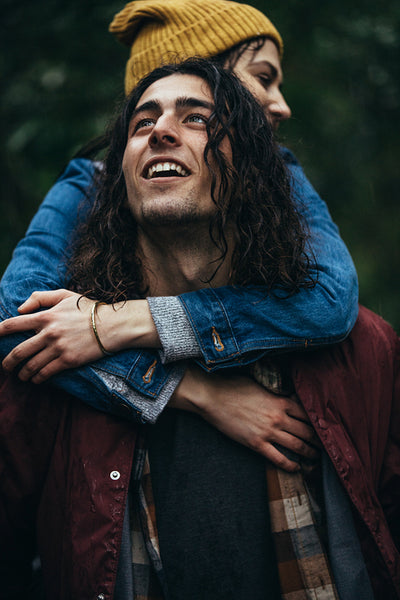 Couple piggybacking in rain outdoors