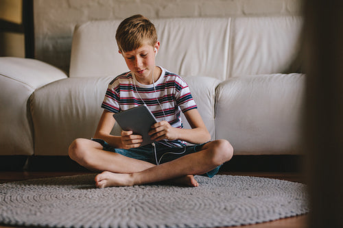 Boy playing online game on tablet at home