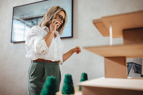 Architect discussing building design while working in a bright office environment