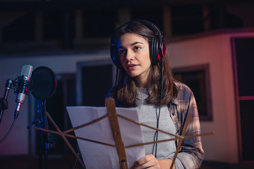 Woman recording a song in music studio