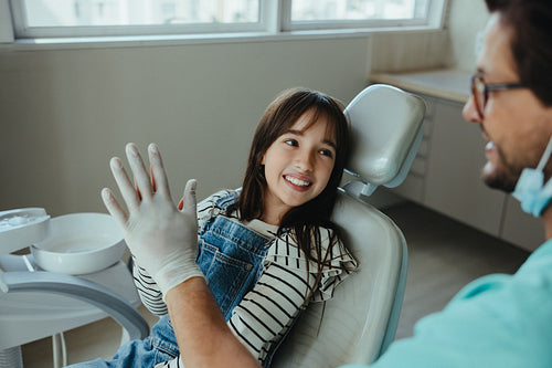 Dentist commends young patient with a high five for bravery in checkup