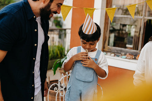 Young child celebrates birthday outdoors with family and colorful decorations