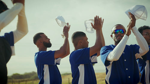 Baseball team celebrates with enthusiastic applause with caps in their hands