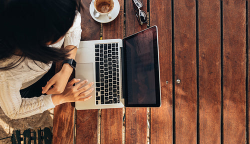 Woman working on her laptop at cafe