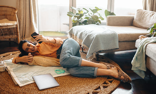 Mother cuddling baby while video calling at home