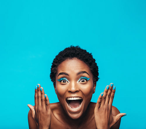 Excited young woman with vibrant makeup