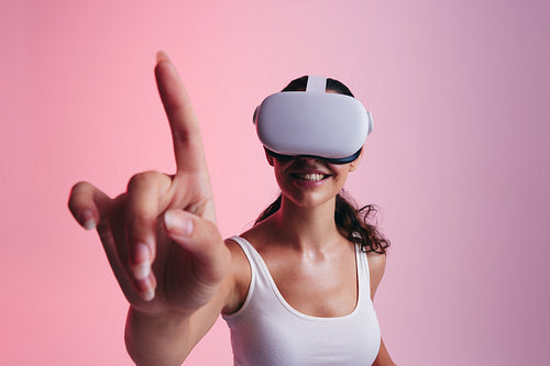 Happy young woman touching virtual space with her finger