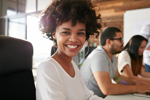 Cheerful african woman in conference room with coworkers