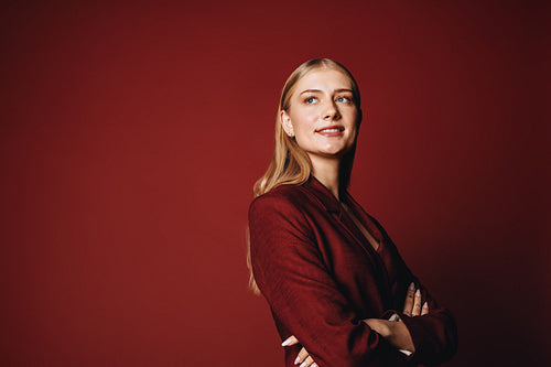Young aspiring entrepreneur posing in red suit with confident expression
