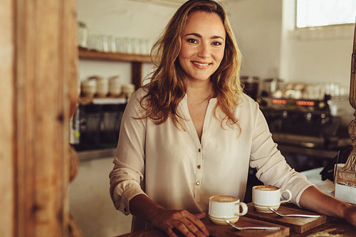 Smiling female barista serving coffee