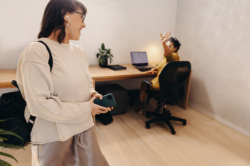Colleague waving goodbye in an office at the end of the day