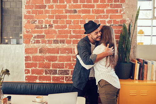 Young man greeting a woman at cafe