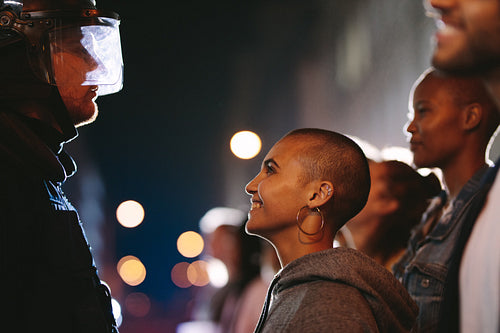 Female activist smiling at the policeman during a protest