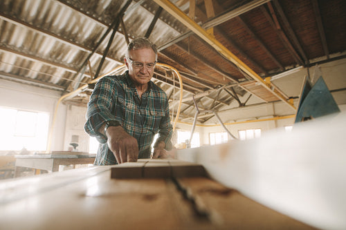 Senior male carpenter working in carpentry workshop