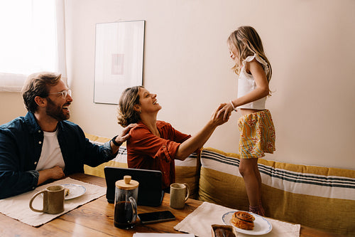 Family moment: parents play with daughter at home
