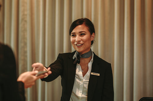 Receptionist receiving payment for hotel room from client