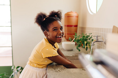 Happy young Brazilian girl cleaning her hands at home