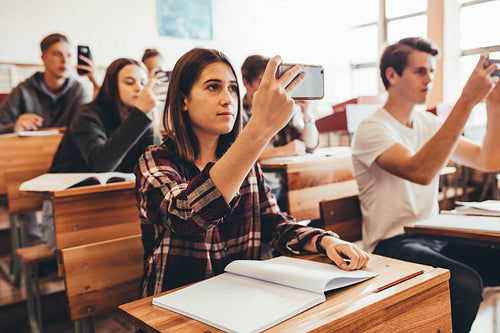 Students recording the lecture in classroom