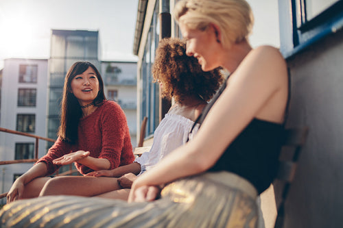 Multiracial women relaxing outdoors in a balcony