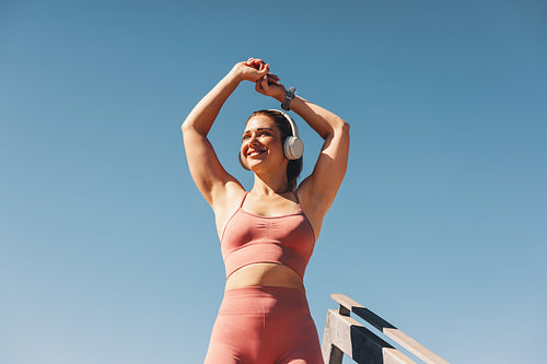 Woman in sportswear stretching her arms outdoors