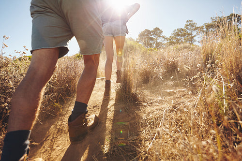 Two people going uphill on a mountain trail