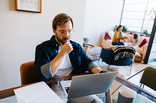 Man works on laptop in bright home office