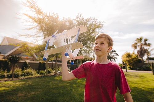Young boy running with a toy airplane