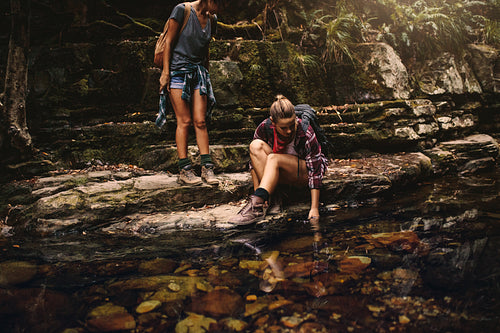 Female hikers by a water pond in mountain
