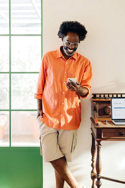 Mature man smiling while using a mobile phone for remote work