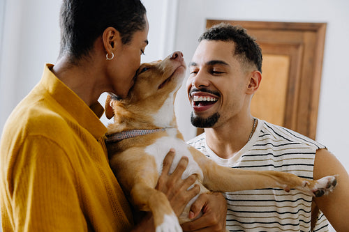 Young couple embracing their dog in a warm and joyful moment