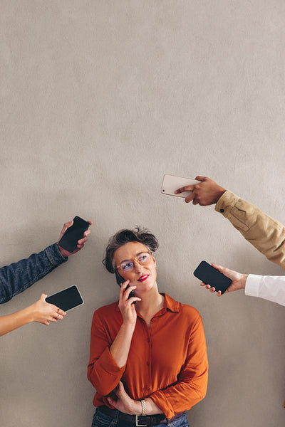 Mature businesswoman speaking on the phone in a busy work environment
