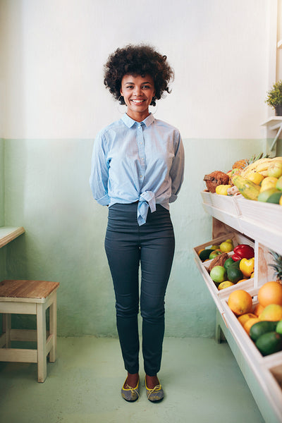 Happy young african woman standing in a juice bar