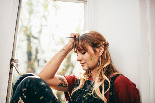 Beautiful woman sitting at window and thinking