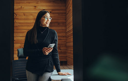 Young businesswoman using a smartphone in a modern office