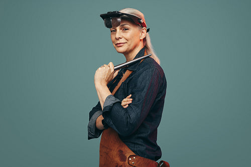Professional goldsmith holding a ring mandrel in a studio