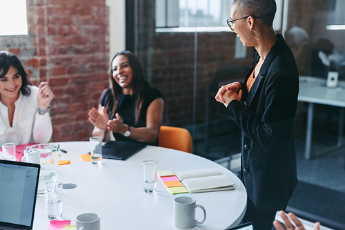 Businesswoman receiving praise from her colleagues in an office