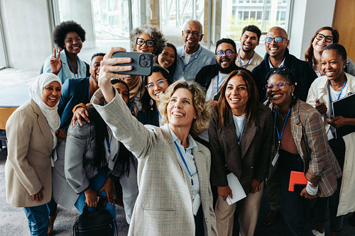 Smiling colleagues taking a selfie at a corporate event for team bonding