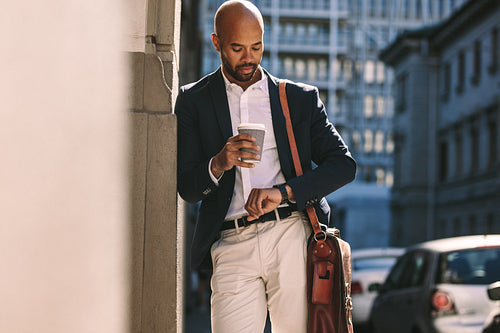 Businessman checking time outdoors