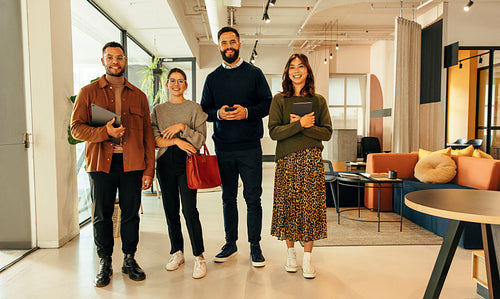 Four businesspeople standing together in a modern office