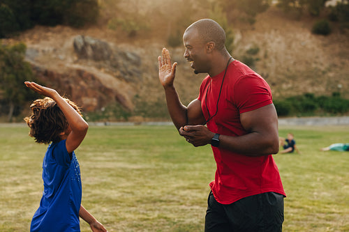 Coach and student giving each other a high five during sports training