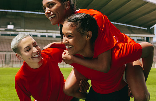 Teammates holding the goal scorer and celebrating in field