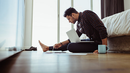 Man working on laptop sitting at home