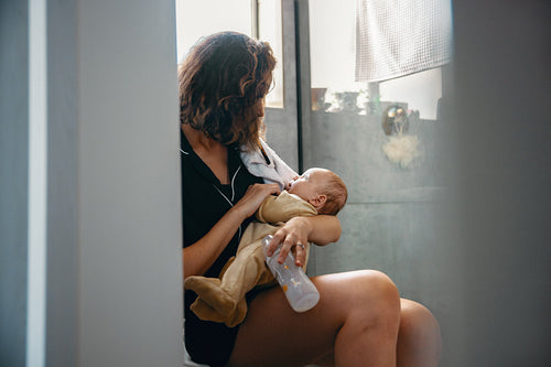 Mother sits in bathroom with baby