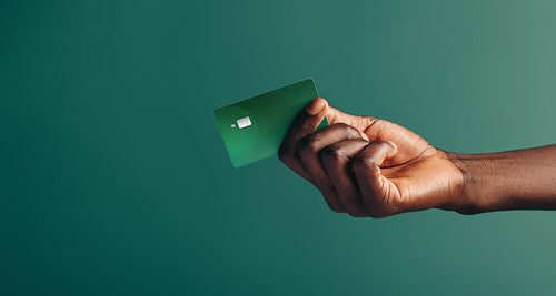 Man making a cashless purchase with a green credit card
